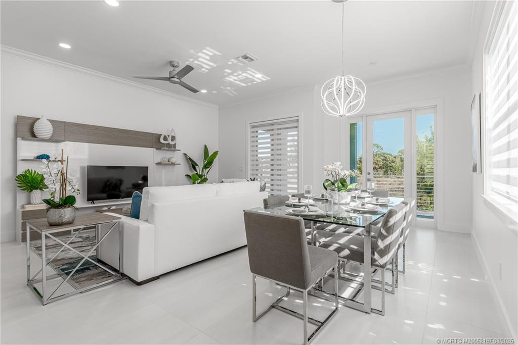 4674 Southeast Manatee Terrace Stuart, FL 34997 - Photo 35 of 55 a view of a dining room with furniture a chandelier and large windows