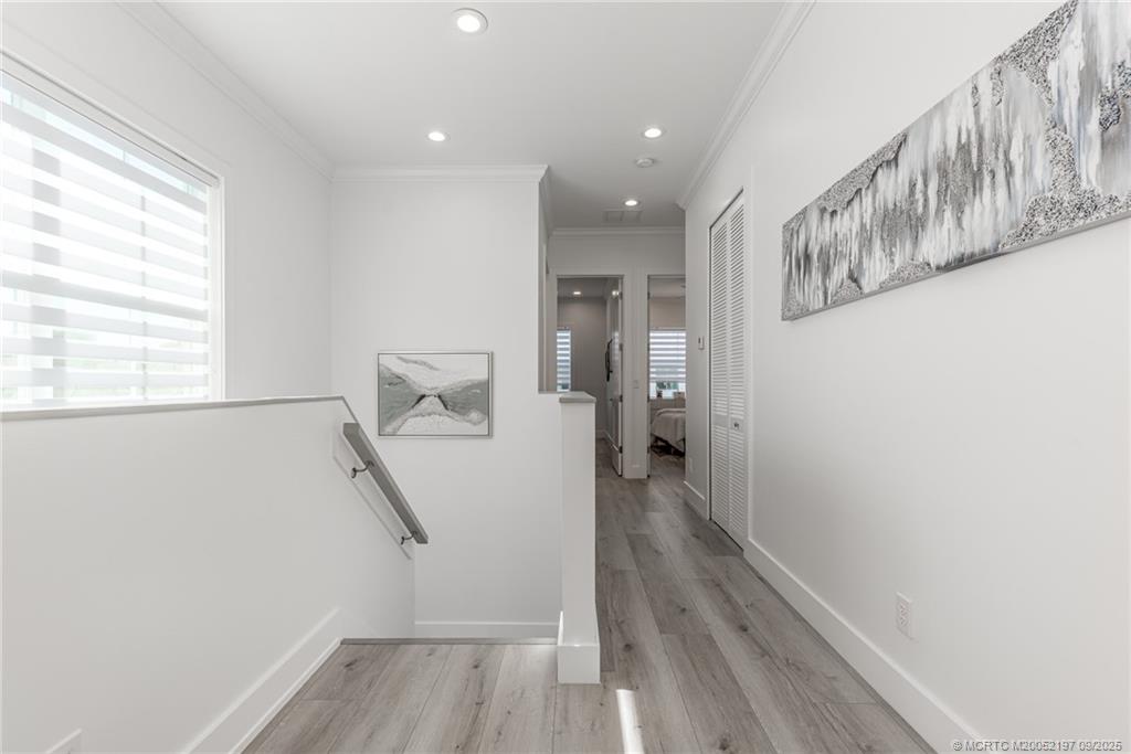 4674 Southeast Manatee Terrace Stuart, FL 34997 - Photo 43 of 55 a view of hallway with stairs and wooden floor