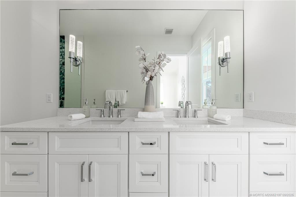 4674 Southeast Manatee Terrace Stuart, FL 34997 - Photo 50 of 55 a bathroom with a sink vanity and a mirror