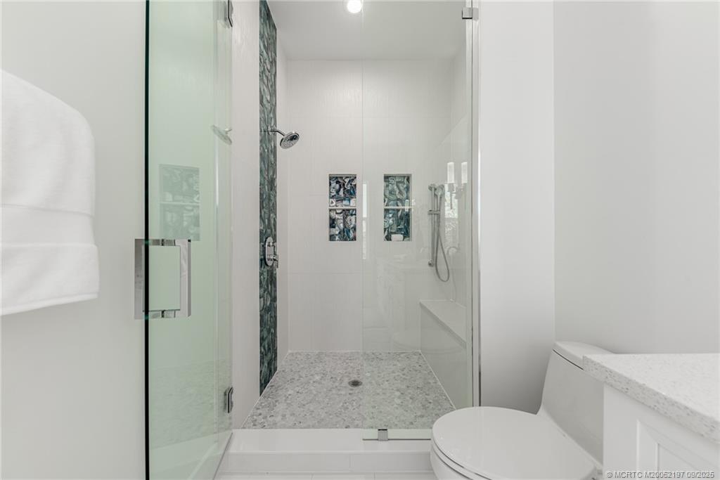 4674 Southeast Manatee Terrace Stuart, FL 34997 - Photo 51 of 55 a bathroom with a toilet and shower