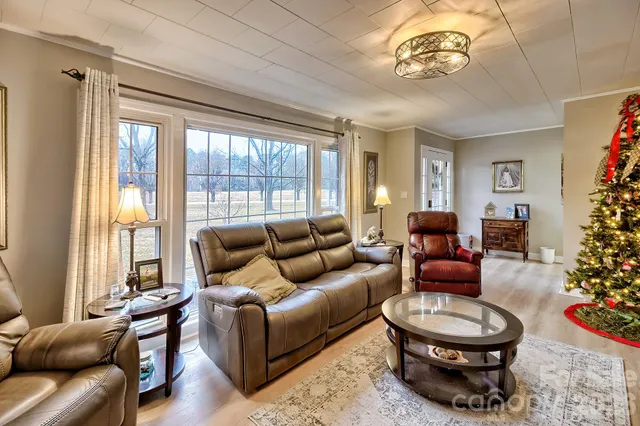 a living room with furniture a flat screen tv and a large window