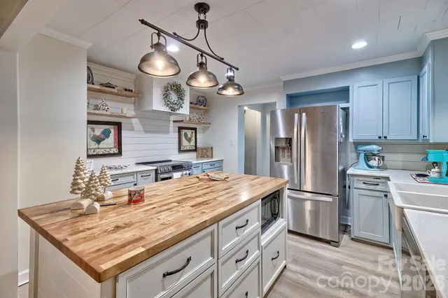 a kitchen with stainless steel appliances granite countertop a sink refrigerator stove and microwave
