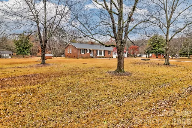a yellow house with trees in front of it