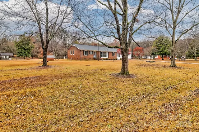 a yellow house with trees in front of it