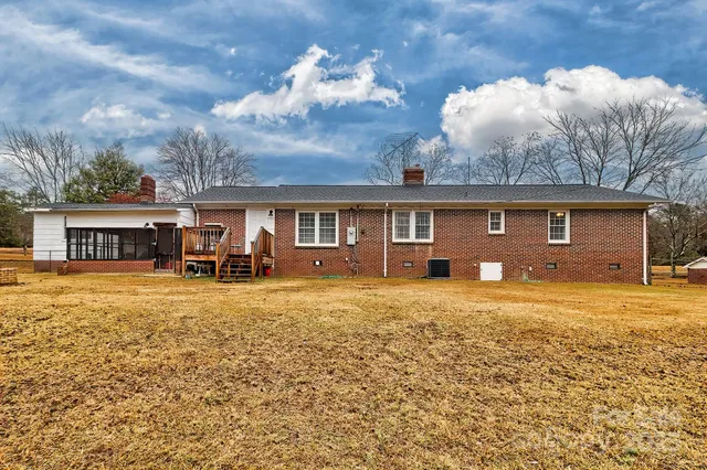 a view of a house with a yard and a large tree