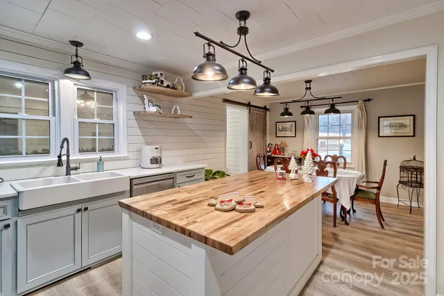 a kitchen with a counter top space a sink stainless steel appliances and cabinets