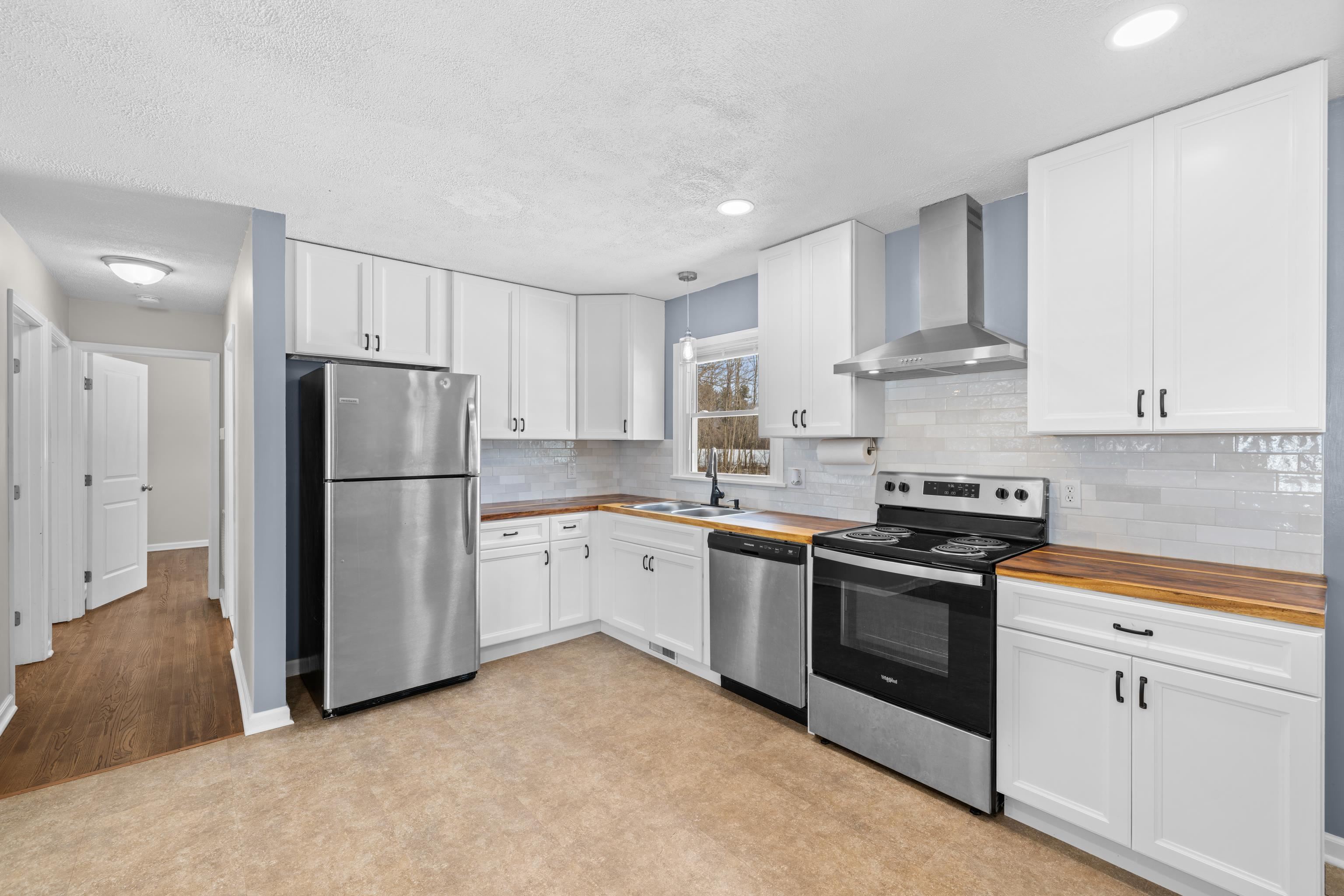 7540 Spring Creek Road Bridgewater, VA 22812 - Photo 10 of 42 a kitchen with white cabinets and stainless steel appliances