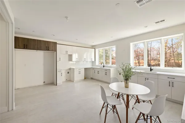 a kitchen with stainless steel appliances a dining table and chairs