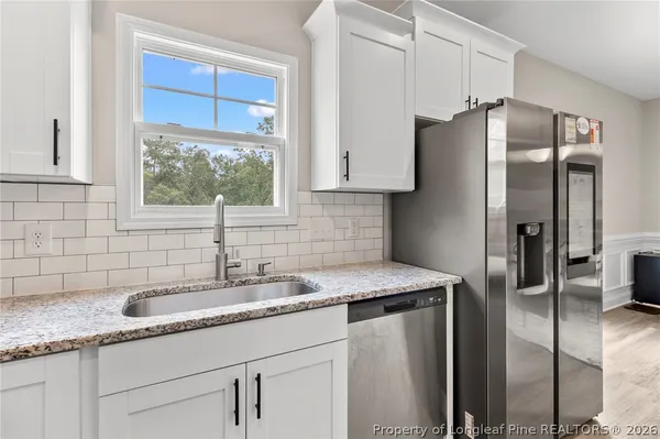 a kitchen with stainless steel appliances granite countertop a refrigerator and a sink