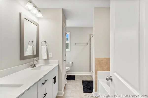 a bathroom with a tub sink and mirror