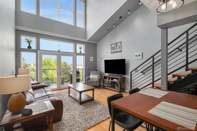 a living room with furniture a flat screen tv and a large window