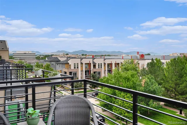 a view of a city from a balcony with seating space