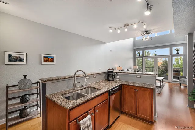 a kitchen with a sink stove and wooden floor