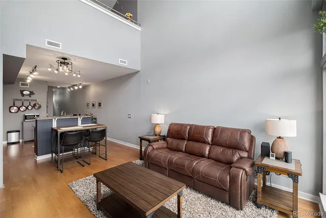 a living room with furniture a table and wooden floor