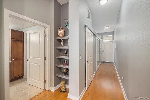 a view of a hallway with wooden floor and entryway