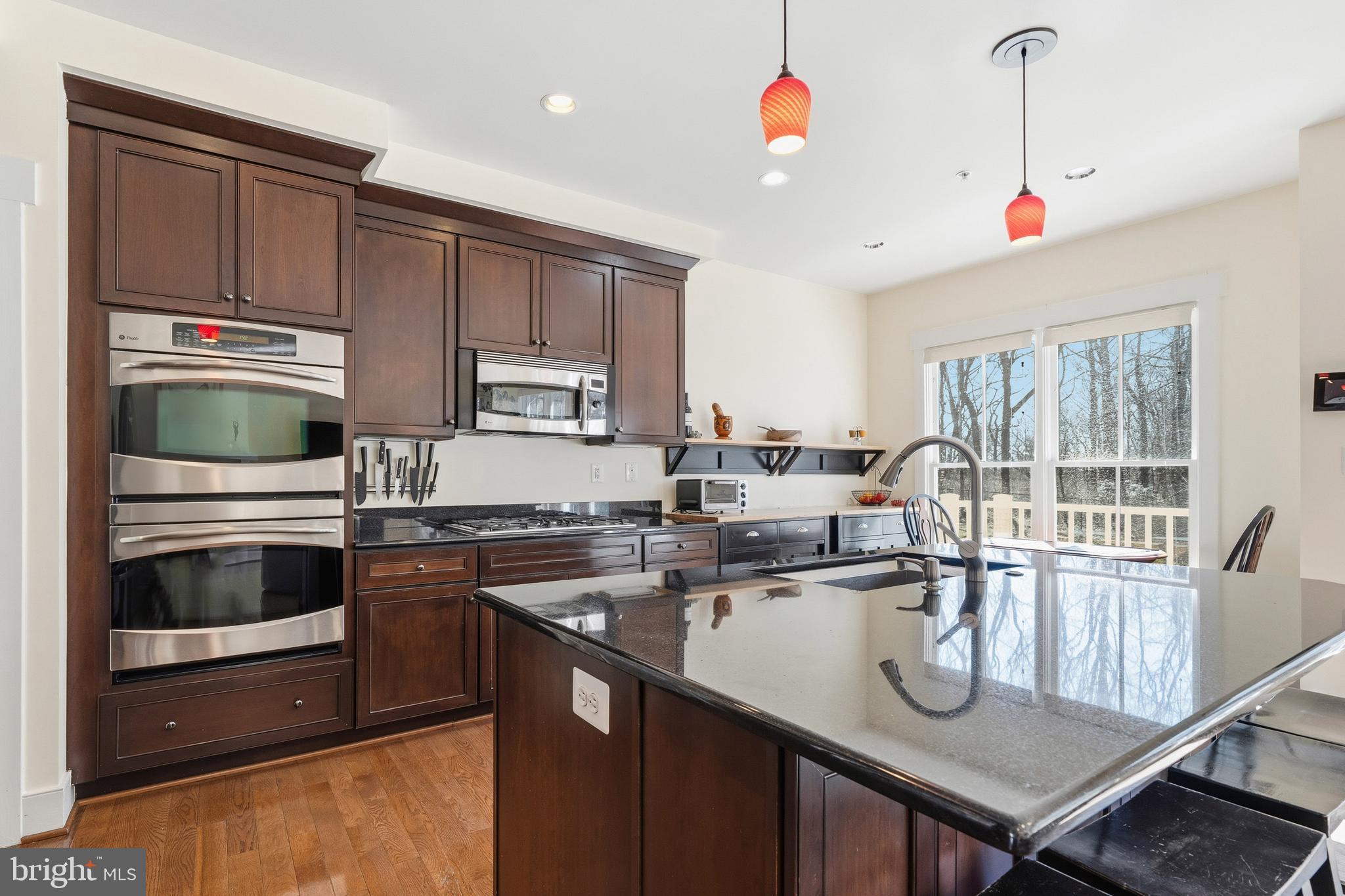 9530 Ament Street Silver Spring, MD 20910 - Photo 8 of 55 a kitchen with kitchen island granite countertop a sink appliances and cabinets
