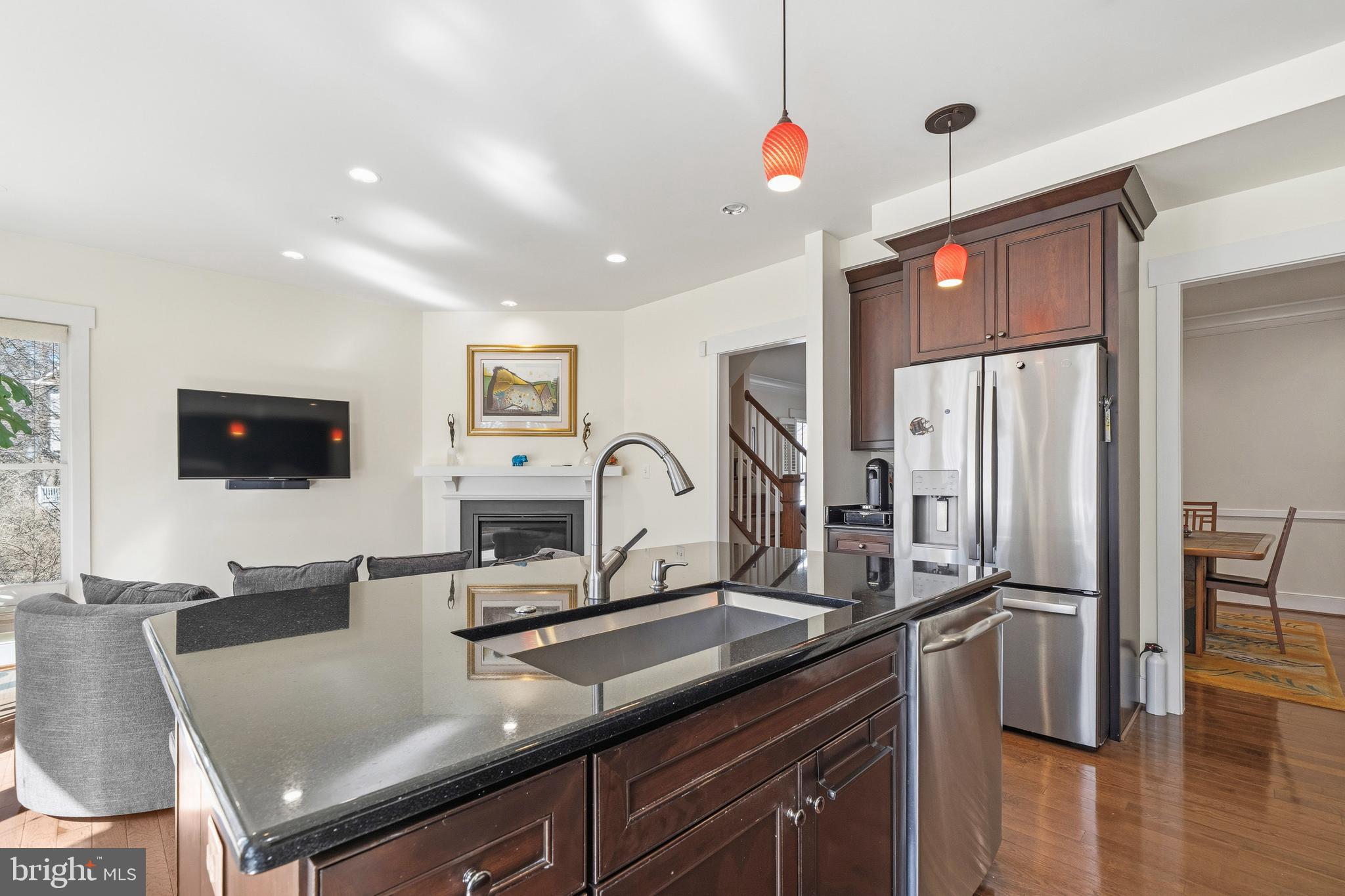 9530 Ament Street Silver Spring, MD 20910 - Photo 10 of 55 a kitchen with stainless steel appliances granite countertop a sink dishwasher a refrigerator and a dining table with wooden floor