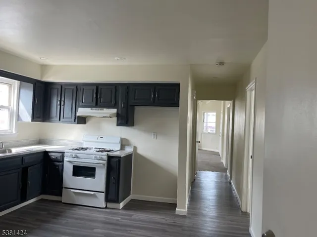 a kitchen with stainless steel appliances a stove a refrigerator and wooden cabinets