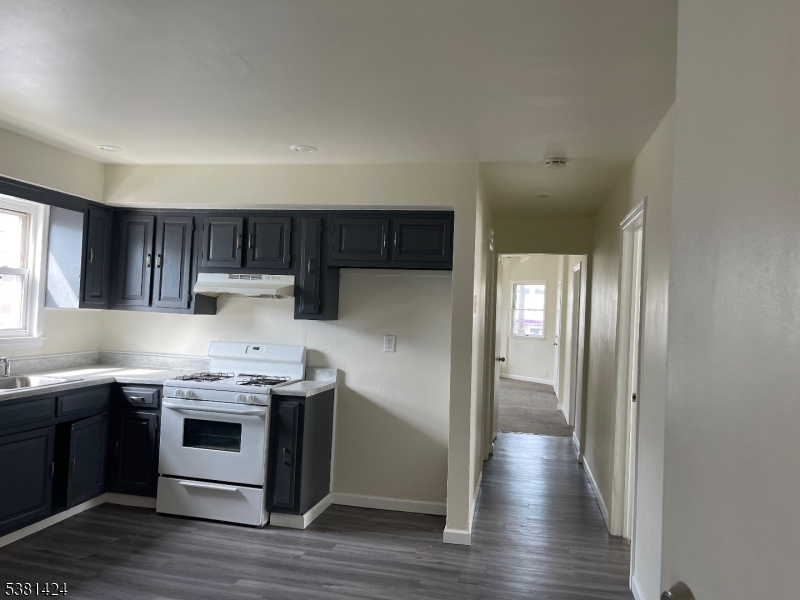 242 Union Avenue Paterson, NJ 07502 - Photo 9 of 10 a kitchen with stainless steel appliances a stove a refrigerator and wooden cabinets