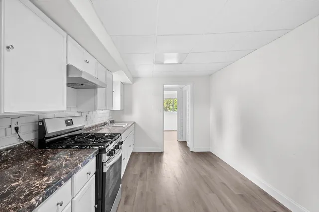 a kitchen with stainless steel appliances granite countertop a stove a sink and a refrigerator