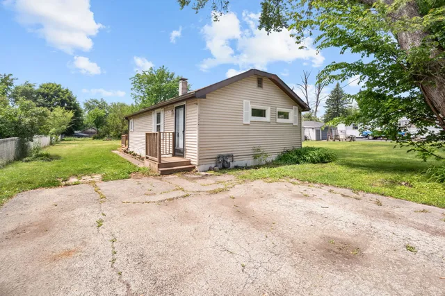 a view of a house with a yard and large trees