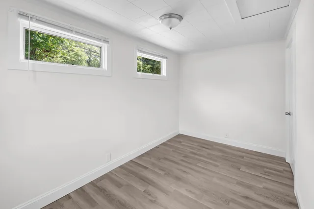 an empty room with wooden floor and window