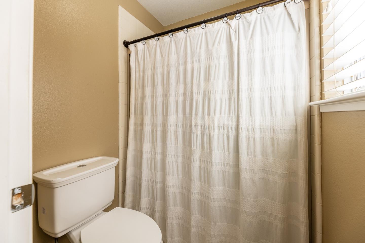 1118 Eagle Drive Salinas, CA 93905 - Photo 24 of 30 a white toilet sitting next to a shower curtain