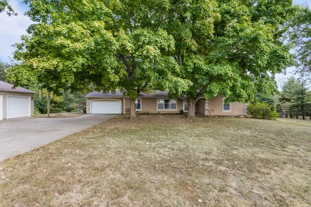 a view of a house with a yard and a tree