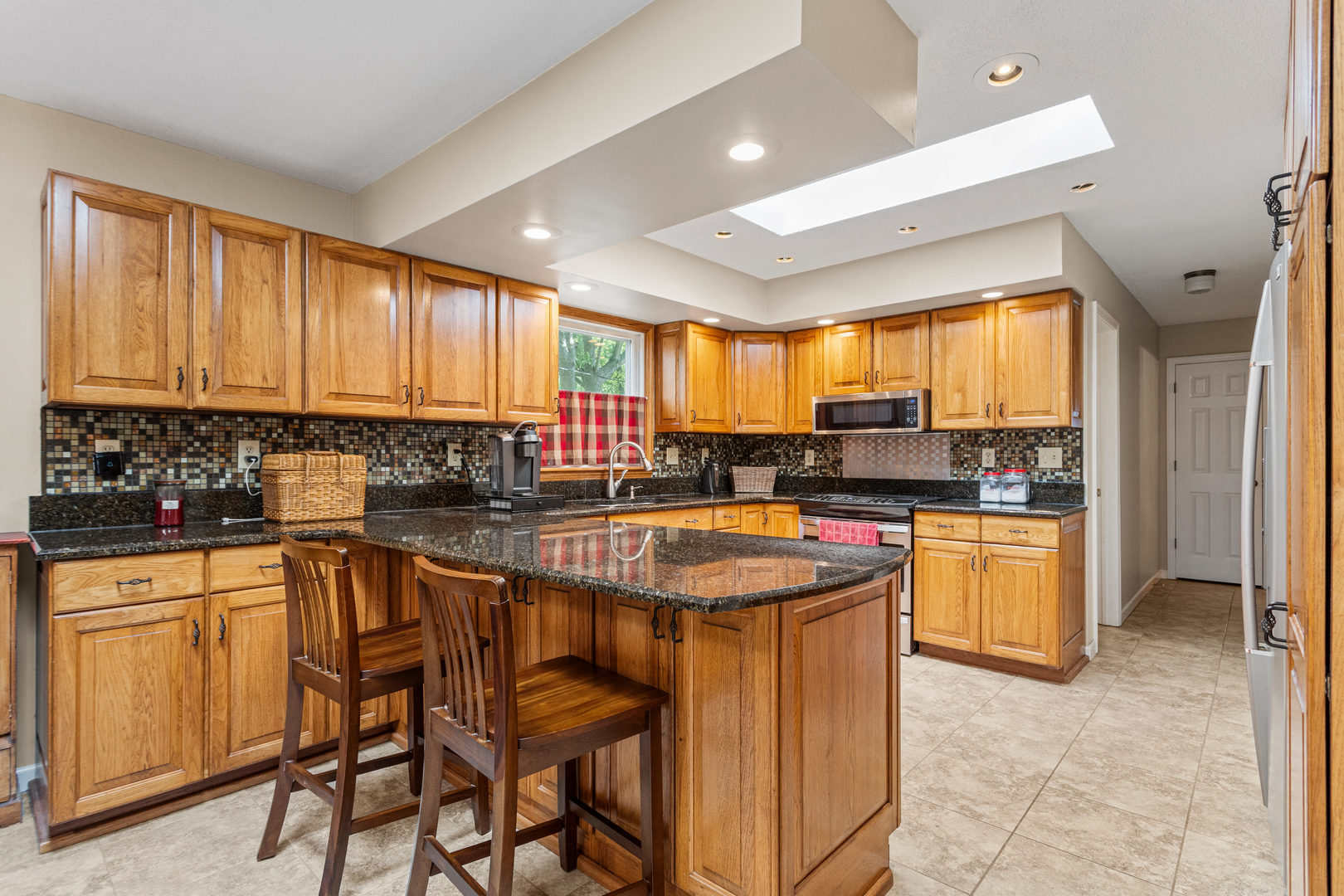 2073 Coyote Run Road Monticello, IL 61856 - Photo 11 of 42 a kitchen with stainless steel appliances granite countertop wooden cabinets a sink and a stove