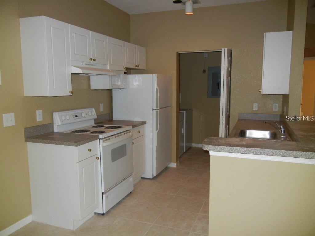 873 Grand Regency Pointe, Unit 105 Altamonte Springs, FL 32714 - Photo 8 of 24 a kitchen with a sink a stove and refrigerator