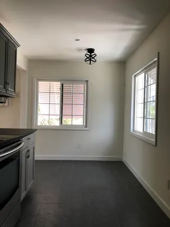 an empty room with windows and furniture
