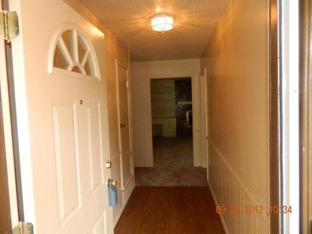 6902 Flint Avenue Lubbock, TX 79413 - Photo 4 of 10 a view of a hallway with a door and wooden floor
