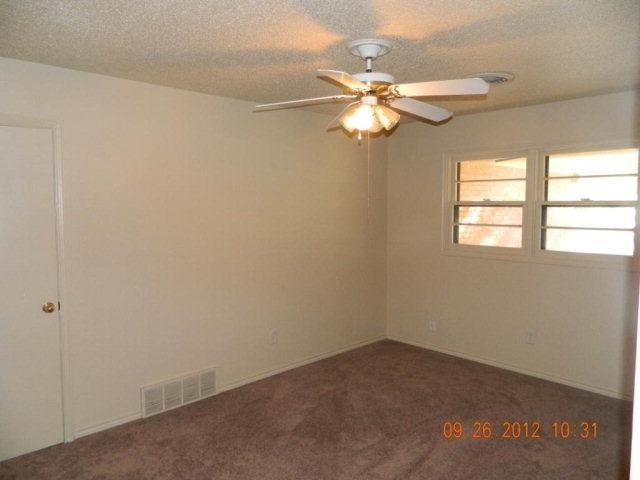 6902 Flint Avenue Lubbock, TX 79413 - Photo 9 of 10 an empty room with windows and fan