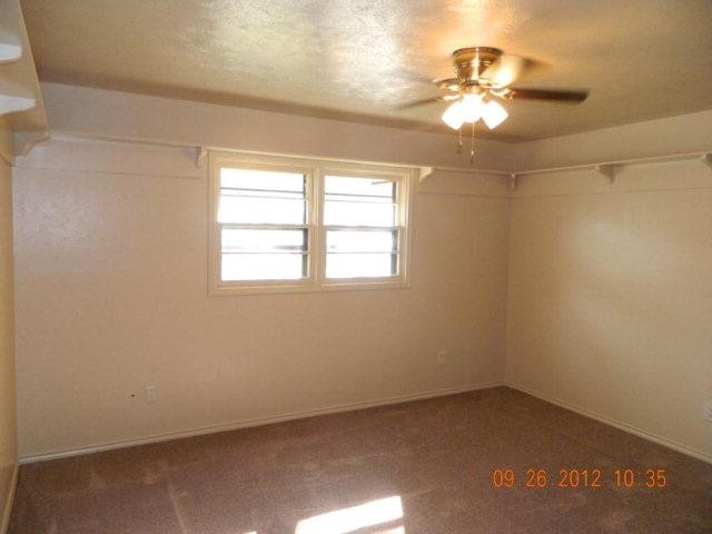 6902 Flint Avenue Lubbock, TX 79413 - Photo 10 of 10 en empty room with windows and chandelier fan