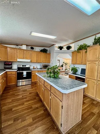 a kitchen with stainless steel appliances granite countertop a kitchen island a stove a sink and a microwave