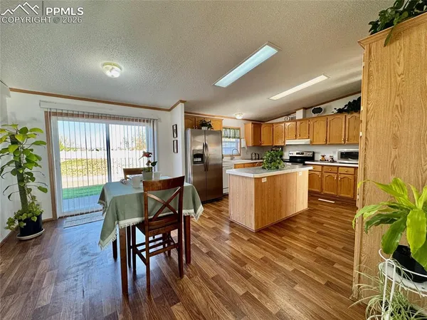 a kitchen with stainless steel appliances kitchen island granite countertop wooden floors and wooden cabinets