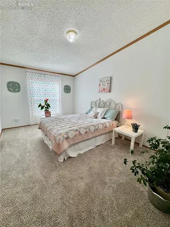 a bedroom with a bed and a potted plant on the dresser