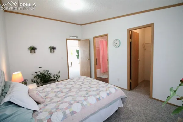 a bedroom with a bed and a potted plant