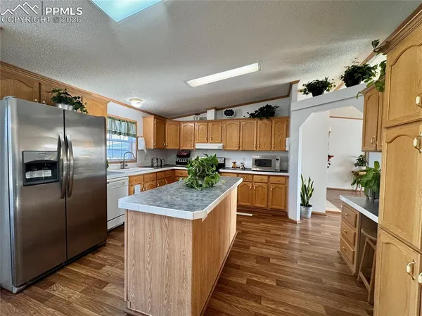 a kitchen with granite countertop a refrigerator and a sink