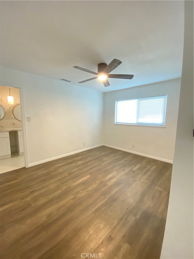1313 West Avenue Fullerton, CA 92833 - Photo 12 of 20 an empty room with wooden floor chandelier fan and windows