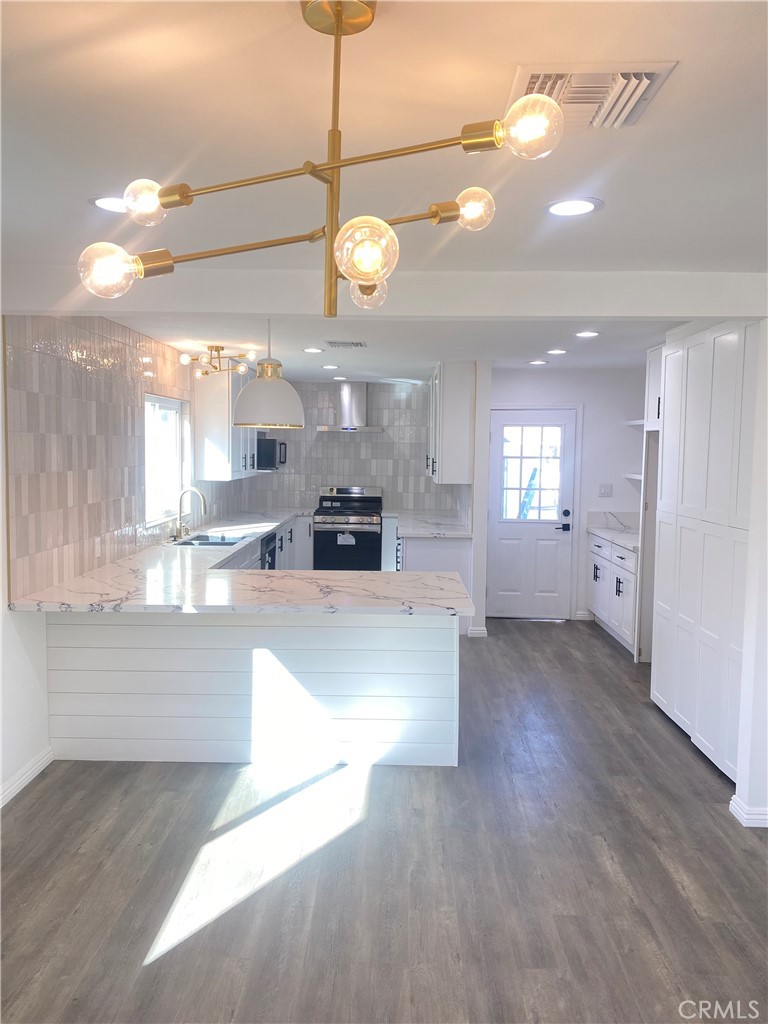 1313 West Avenue Fullerton, CA 92833 - Photo 2 of 20 a view of a kitchen with a sink and dishwasher cabinet with wooden floor