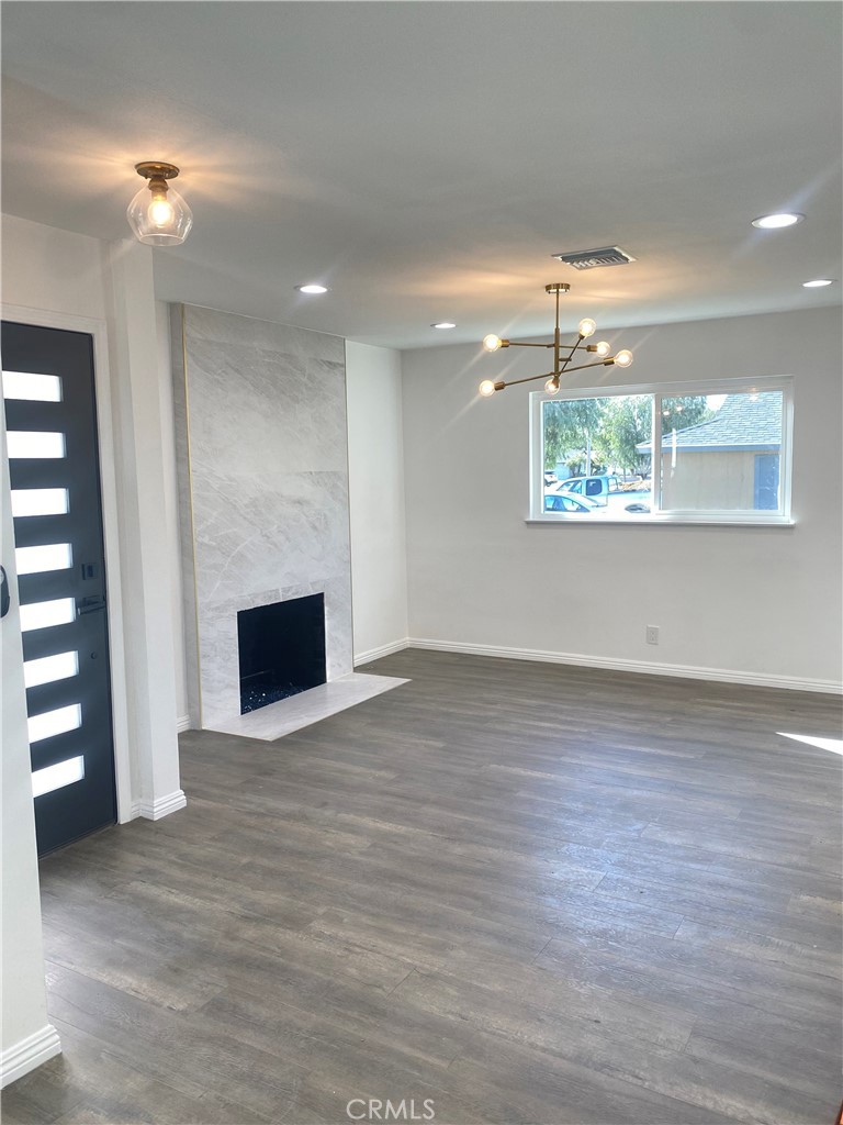 1313 West Avenue Fullerton, CA 92833 - Photo 4 of 20 an empty room with wooden floor and kitchen view