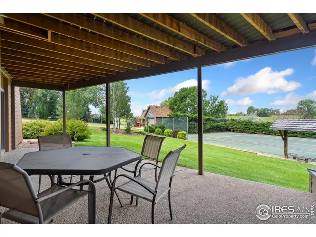 a view of a house with a big yard potted plants and large tree