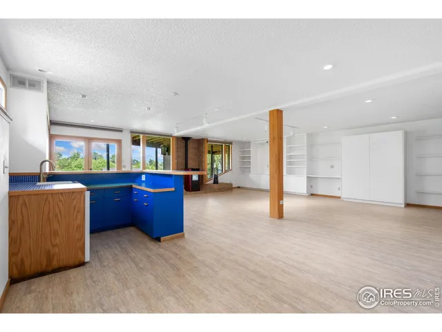 a spacious bedroom with a bed lamp and large window