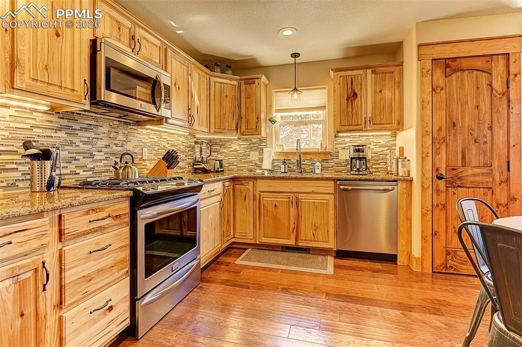 140 Dewell Road Woodland Park, CO 80863 - Photo 11 of 28 a kitchen with stainless steel appliances granite countertop a stove a sink dishwasher and a refrigerator