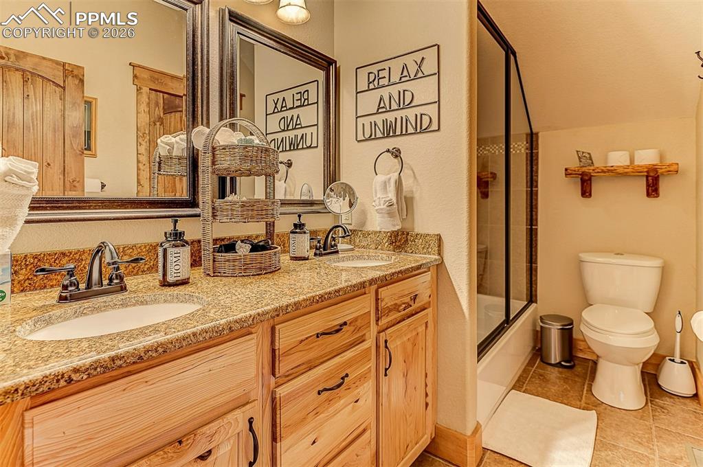 140 Dewell Road Woodland Park, CO 80863 - Photo 20 of 28 a bathroom with a granite countertop sink mirror vanity and toilet