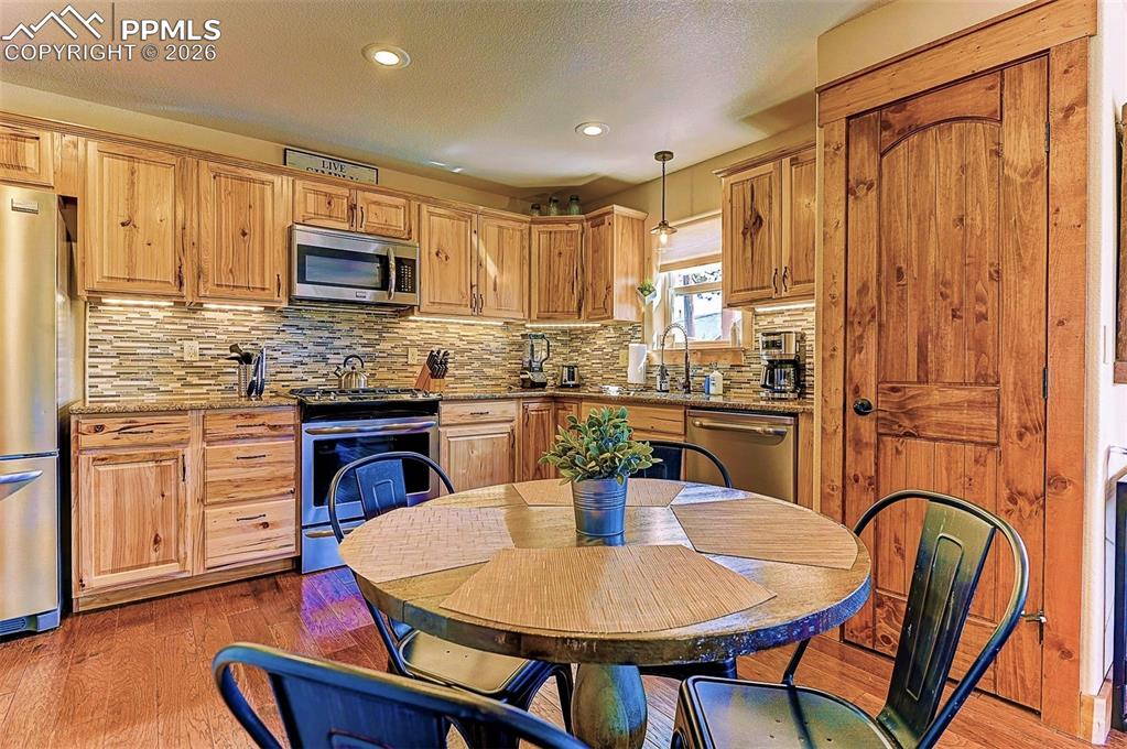 140 Dewell Road Woodland Park, CO 80863 - Photo 9 of 28 a kitchen with stainless steel appliances granite countertop a dining table chairs microwave and sink