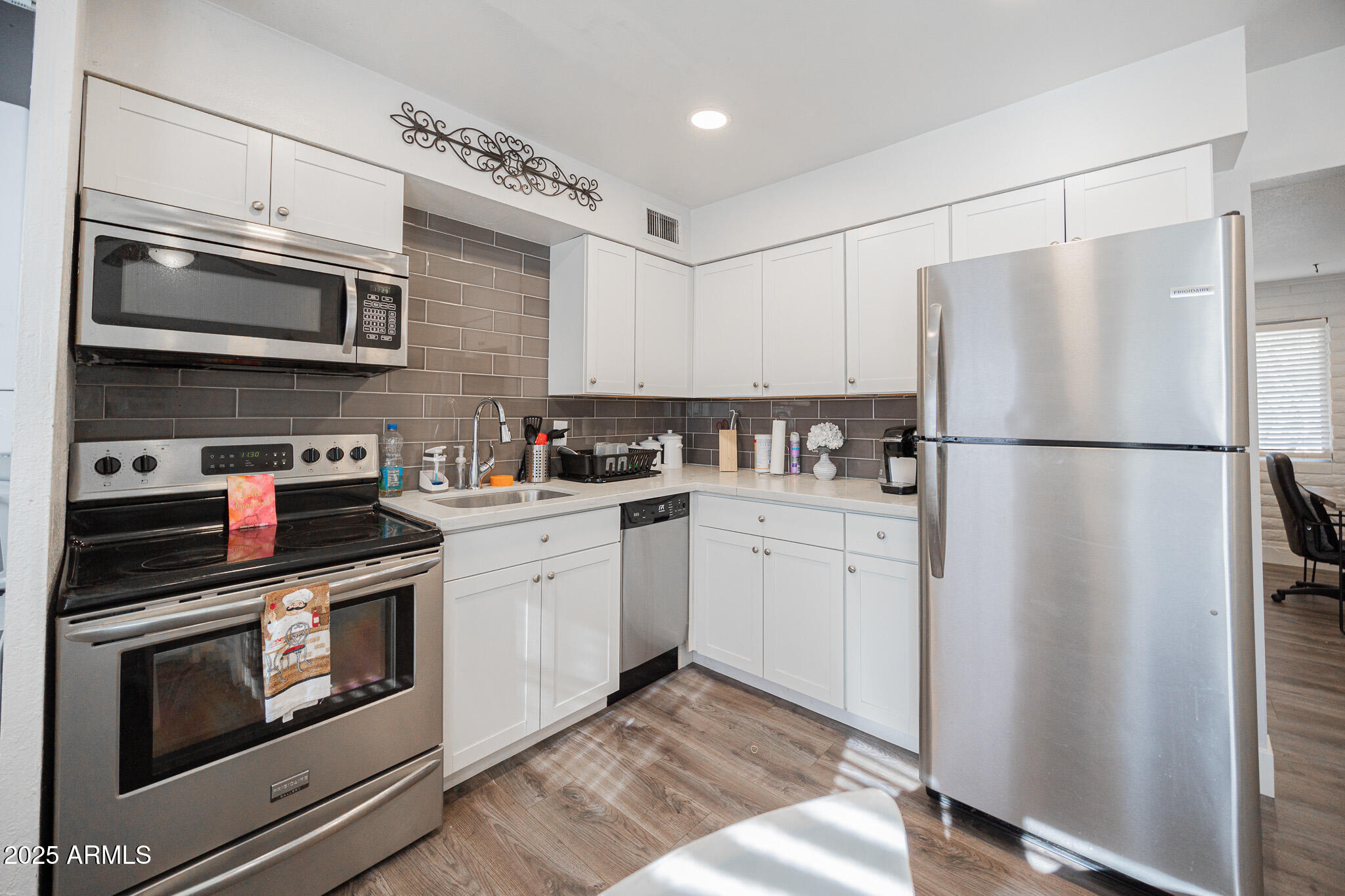 3031 South Rural Road, Unit 9 Tempe, AZ 85282 - Photo 12 of 22 a kitchen with stainless steel appliances granite countertop a refrigerator stove a sink and a microwave