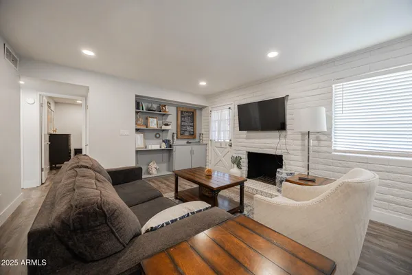 a living room with furniture a fireplace and a flat screen tv