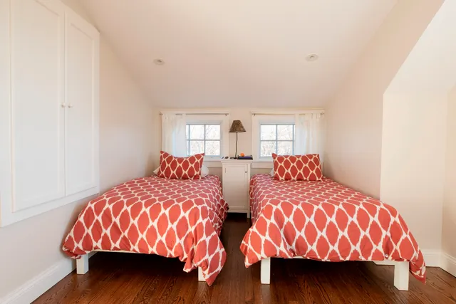 a bedroom with two beds and a lamp